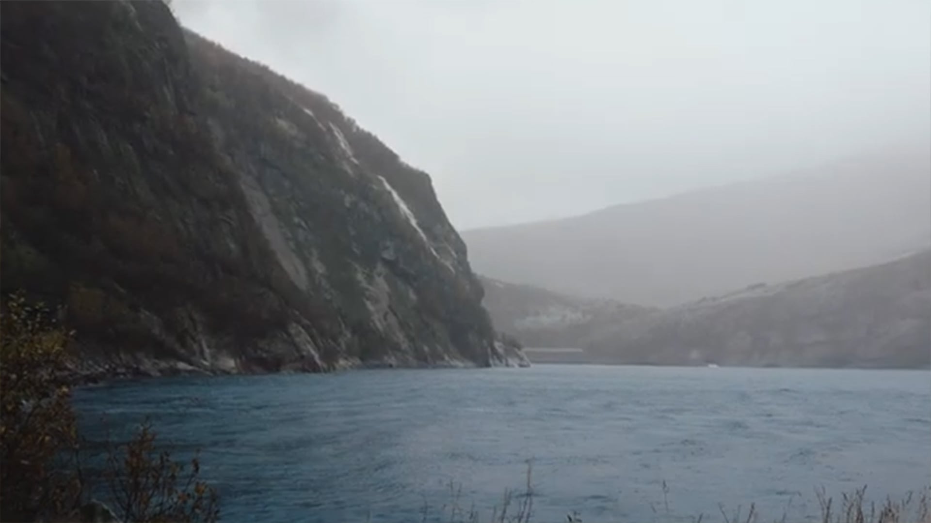 Un impresionante fiordo en Noruega se extiende bajo un cielo cubierto.
