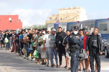 La Policía Nacional traslada a cientos de migrantes que permanecían durmiendo en la calle al nuevo dispositivo habilitado por el Gobierno junto a la antigua prisión de Los Rosales en Ceuta. (EFE/ Reduan)