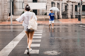 Várias pessoas caminham na chuva, no dia 25 de junho de 2026, em Madrid (Espanha). (Carlos Luján/Europa Press)