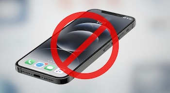 Un teléfono móvil moderno con pantalla oscura y aplicaciones, cubierto por un gran círculo rojo con una línea diagonal que indica prohibición.