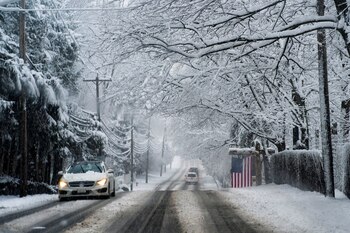Autos circulan bajo la nieve