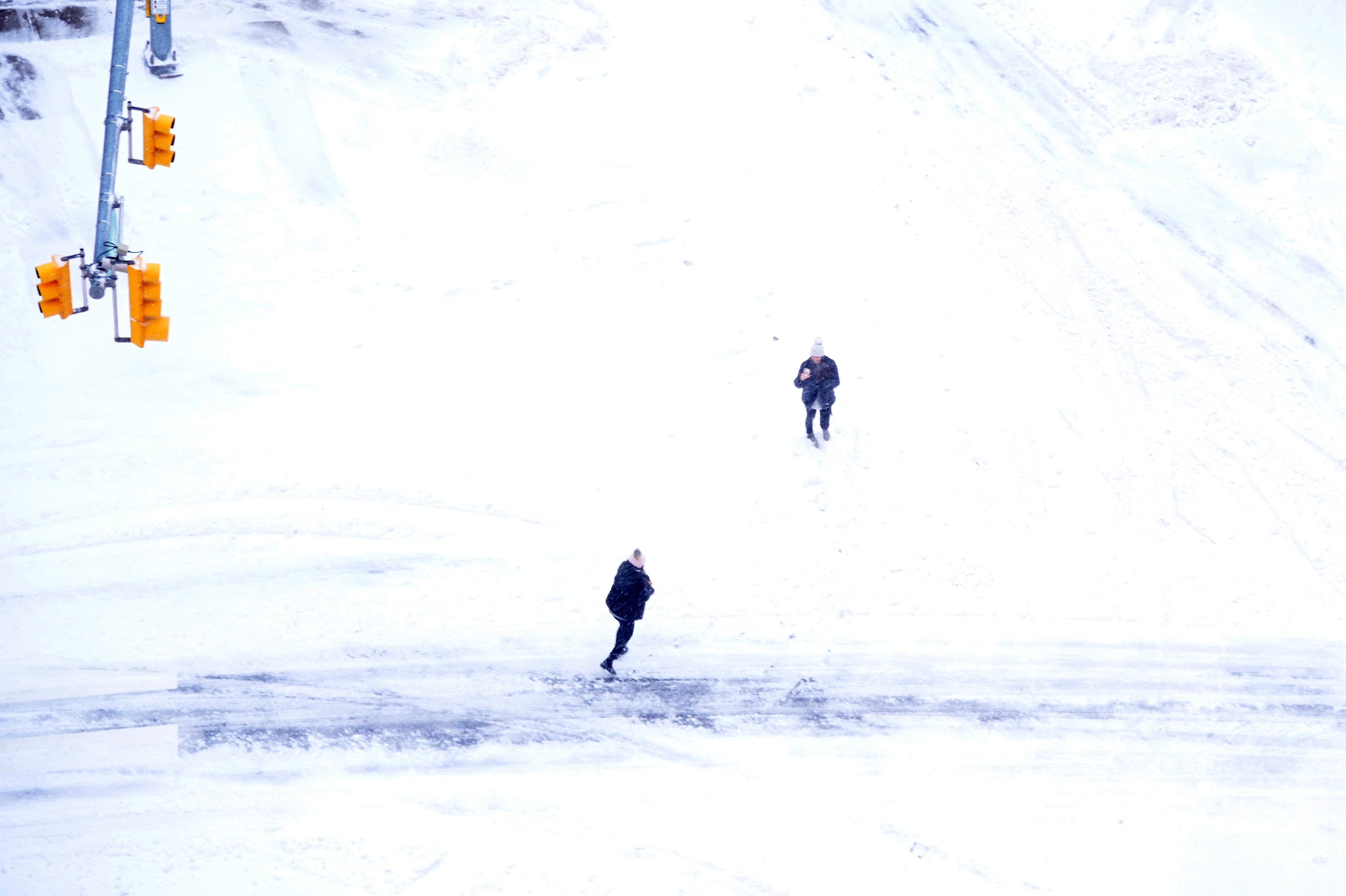 Una persona toma una foto a otra en un vecindario cubierto de nieve durante una tormenta invernal. (Michael Loccisano/ARCHIVO/AFP)