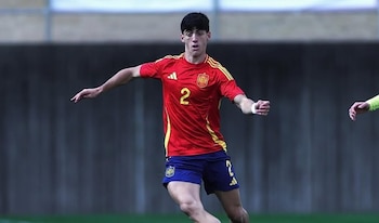 Valentín Pezzolesi corre en la cancha de fútbol usando la camiseta roja número dos y el pantalón azul de España