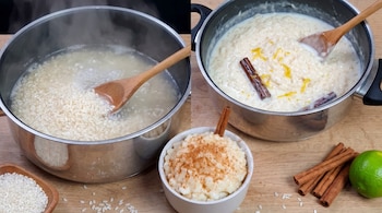 Dos ollas, una con arroz hirviendo en agua y otra con arroz con leche y canela. Un tazón de arroz con leche con canela molida, un cuenco de arroz crudo, limón y ramas de canela en una superficie de madera.
