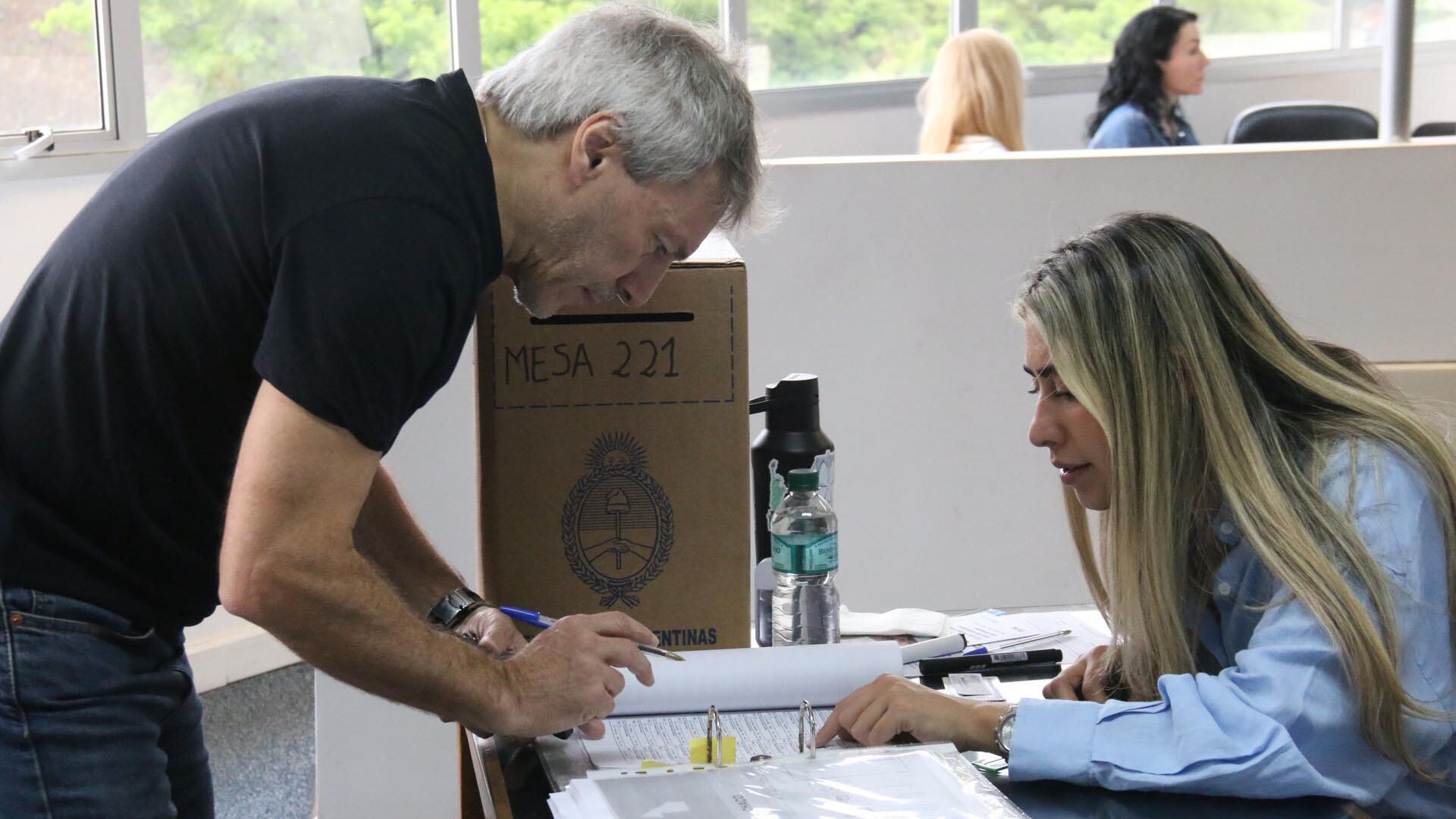 AME2112. ASUNCIÓN (PARAGUAY), 26/10/2025.- Una persona recibe una papeleta de votación este domingo, en Asunción (Paraguay). Decenas de argentinos residentes en Paraguay acudieron a votar en los tres consulados habilitados en el país en unas elecciones legislativas de medio término clave para el Gobierno del presidente de Argentina, Javier Milei, donde el político conservador busca obtener mayorías en el Congreso para llevar a cabo sus reformas. EFE/ Nina Osorio