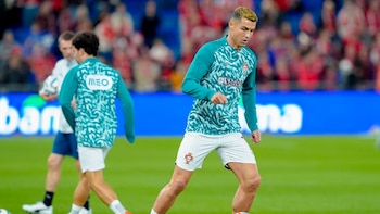 Cristiano Ronaldo viste una camiseta verde y pantalón corto blanco de la selección de Portugal sobre un campo de fútbol