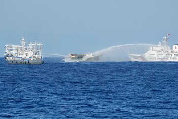 El barco filipino de abastecimiento Unaizah May 4, en el centro, es alcanzado por cañones de agua de dos barcos guardacostas chinos cuando intentaba llegar al disputado atolón Second Thomas, en el Mar de China Meridional (AP Foto/Aaron Favila, Archvo)