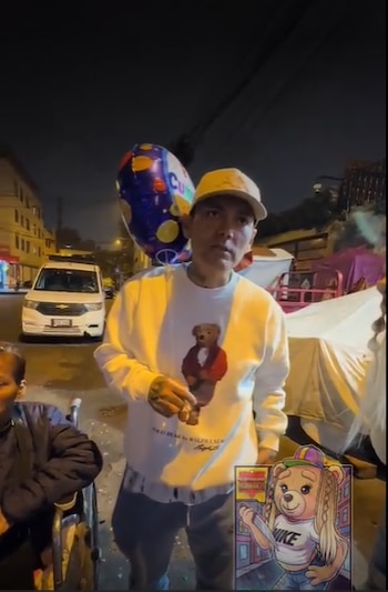 Hombre con sudadera blanca y gorra, globo azul, persona en silla de ruedas, van blanca, calle nocturna. Gráfico de oso animado en esquina inferior