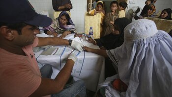 Un médico pakistaní examina a los aldeanos en busca de VIH en un hospital en una aldea cerca de Ratodero, un pequeño pueblo en la provincia sureña de Sindh en Pakistán, donde se produjo el brote de una enfermedad mortal el mes pasado, jueves 16 de mayo de 2019. (AP Photo / Fareed Khan )