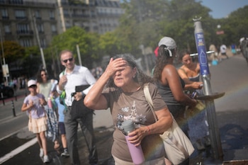 Turistas se refrescan en París en una foto del 26 de junio de 2026. Las autoridades francesas mantienen las alertas tras reportar unas 1.000 muertes por el calor. (AP Foto/C. Ena)
