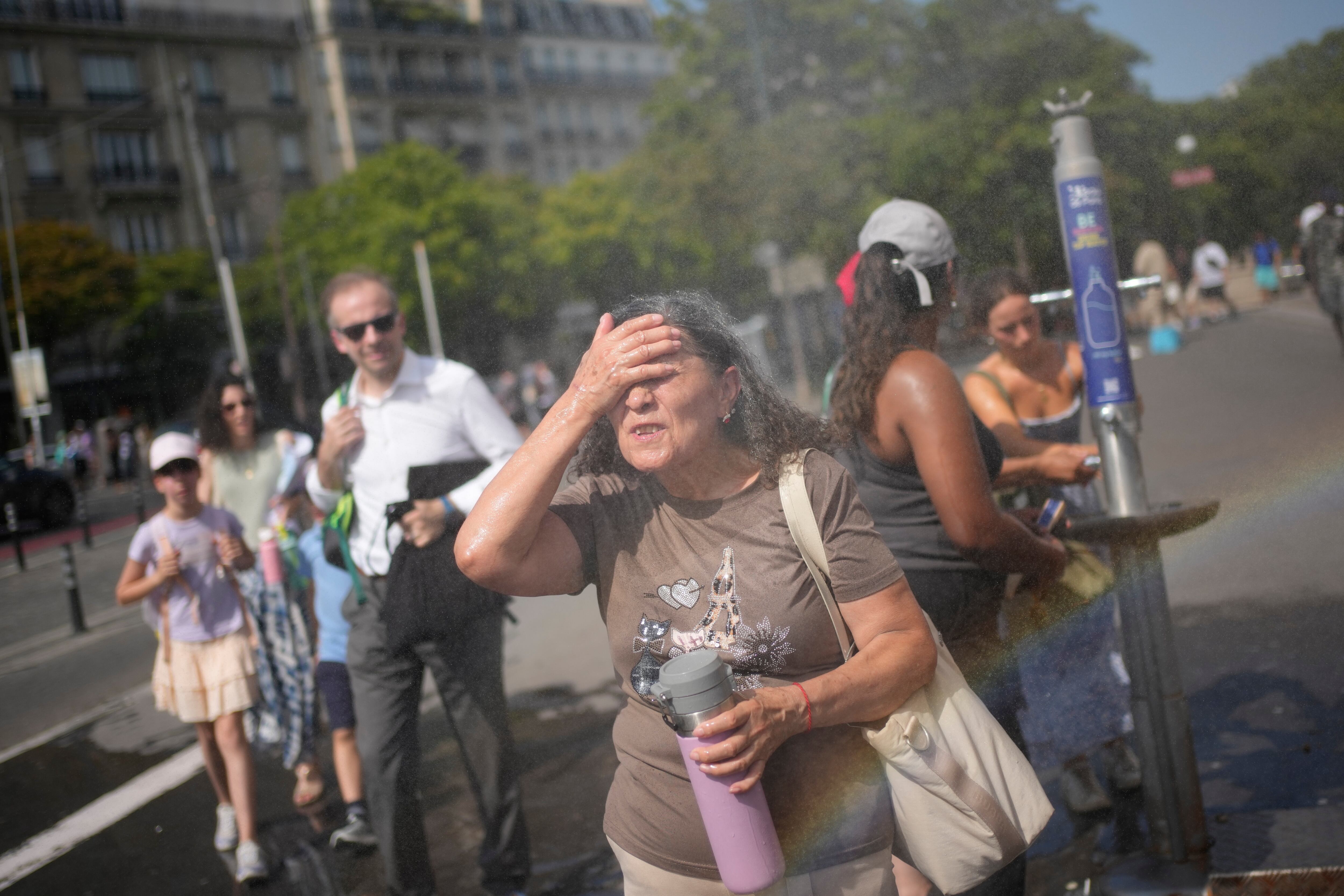 Turistas se refrescan en París en una foto del 26 de junio de 2026. Las autoridades francesas mantienen las alertas tras reportar unas 1.000 muertes por el calor. (AP Foto/C. Ena)