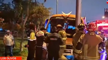 Bomberos y efectivos de seguridad municipal junto al frente destruido de un autobús urbano estrellado contra un poste de alumbrado público