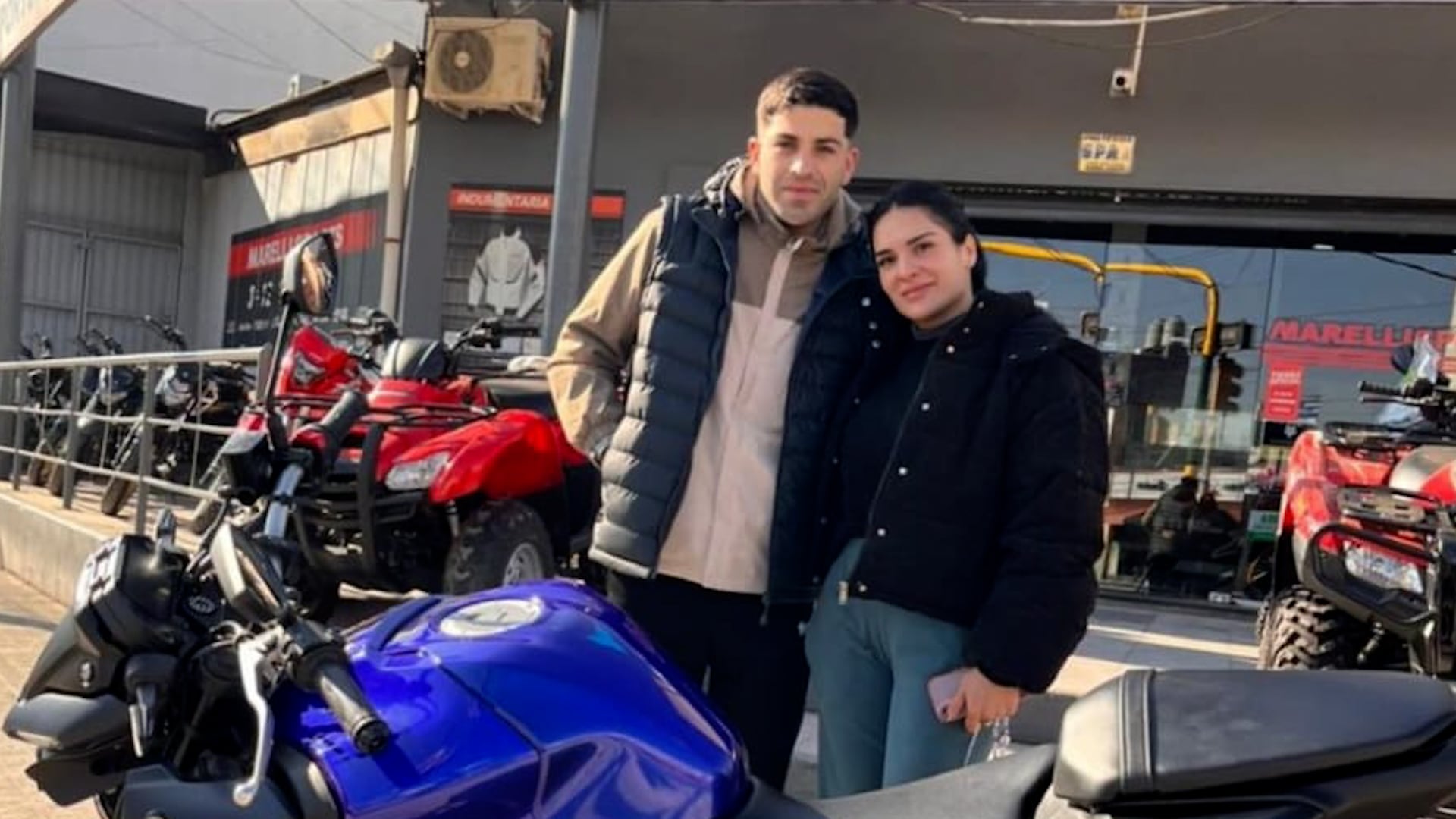 Una policía fue detenida por encubrir a su novio ladrón, en una imagen que los muestra juntos frente a una tienda de motos.