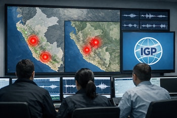 Tres personas de espaldas observan múltiples pantallas en una sala de monitoreo sísmico; se ven mapas de Perú con puntos de alerta roja, gráficos de ondas y el logo del IGP.
