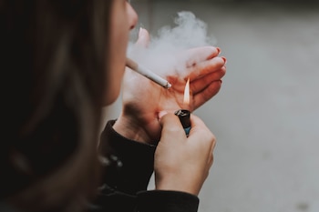Una mujer fumando un cigarro (Magnific)