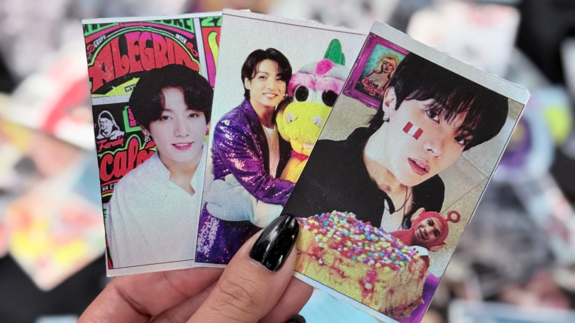 Una seguidora sostiene tarjetas impresas con imágenes del grupo BTS en las inmediaciones del Estadio San Marcos de Lima. (Infobae / Paula Díaz Elizalde)