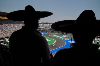 Dos charros disfrutan de la Fórmula 1 desde la tribuna. (AP Foto/Fernando Llano, archivo)