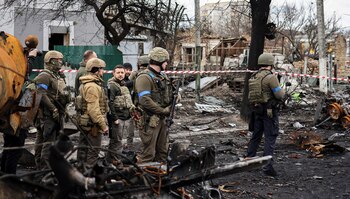 Ukainian President Volodymyr Zelensky (3rdL) stands in the town of Bucha, northwest of the Ukrainian capital Kyiv, on April 4, 2022. - Ukraine's President Volodymyr Zelensky said on April 3, 2022 the Russian leadership was responsible for civilian killings in Bucha, outside Kyiv, where bodies were found lying in the street after the town was retaken by the Ukrainian army. (Photo by RONALDO SCHEMIDT / AFP)