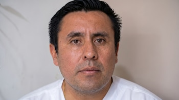 Primer plano del rostro de un hombre con cabello oscuro y barba corta, vestido con camisa blanca y mirando al frente.