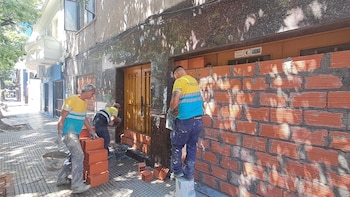 Tres albañiles construyen una pared