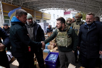 El presidente de Ucrania, Volodymyr Zelenskiy, estrecha la mano de un residente local de Bucha que logró sobrevivir la brutal ocupación rusa (Reuters)