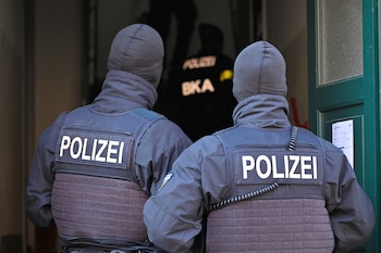 Masked German police officers and an officer of Germany’s Federal Police BKA enter a house after having arrested eight suspected members of a right-wing militant group driven by racist ideology and conspiracy theories who had been training in warfare for the downfall of the modern German state, in Dresden, Germany, November 5, 2024. REUTERS/Matthias Rietschel