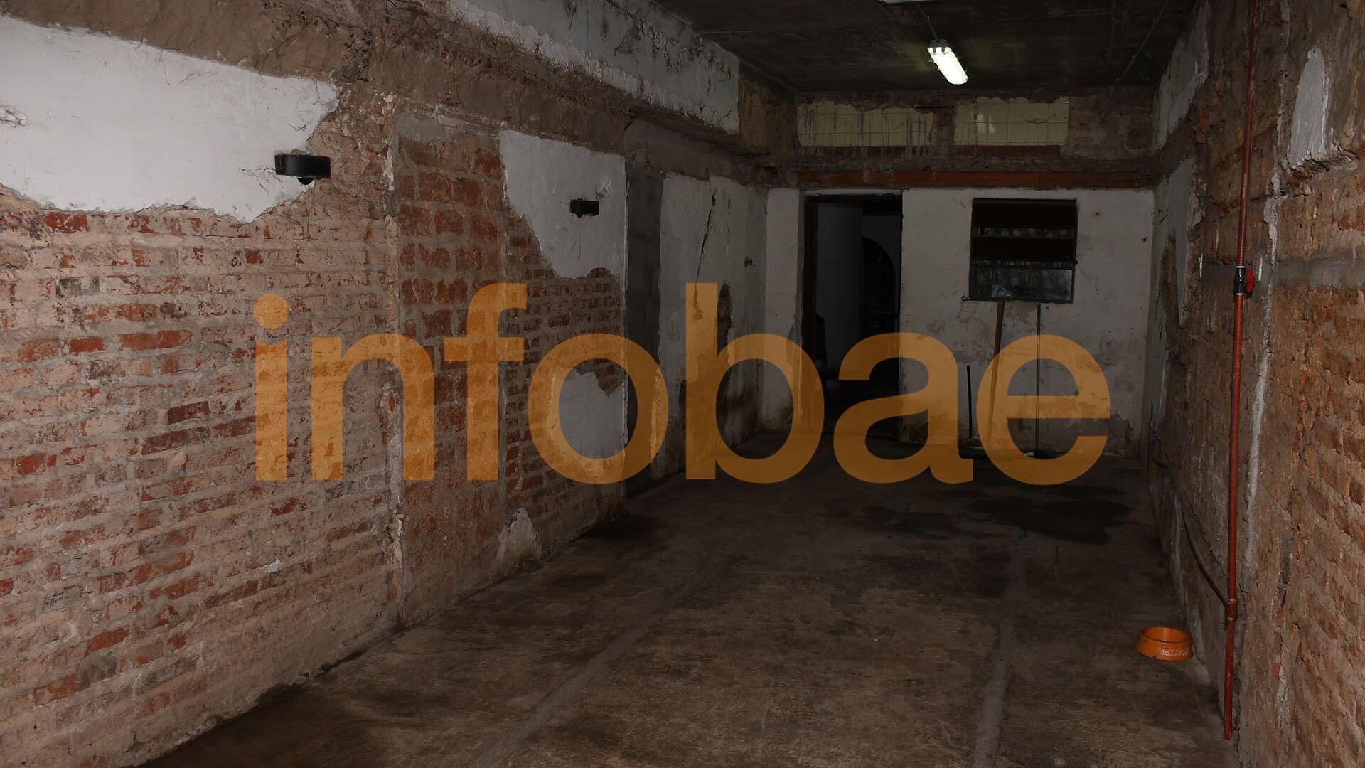 Por la puerta que se ve al fondo, salió del comedor y cruzó hacia el otro lado de la casa a través de una puerta que —como se ve en la imagen— ahora está tapiada con cemento