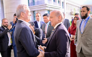 Shehbaz Sharif y Masud Pezeshkian se estrechan las manos rodeados por sus delegaciones y fotógrafos en un espacio exterior