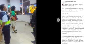 Carlos Vílchez, vestido con camiseta colorida y shorts, junto a un hombre con uniforme de seguridad, observan atentamente un monitor de vigilancia en una sala