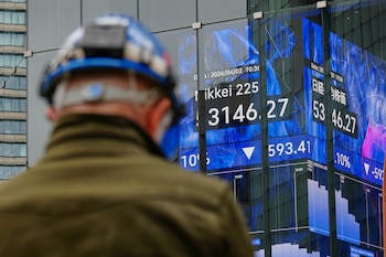 Una persona se encuentra frente a una pantalla electrónica que muestra el índice Nikkei de Japón en una correduría de valores el jueves 2 de abril de 2026, en Tokio (AP/Eugene Hoshiko)