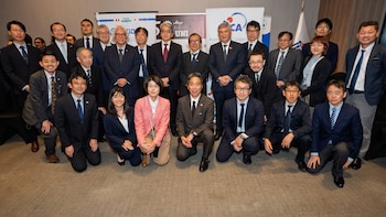 Grupo de veinticinco personas con traje formal, hombres y mujeres, posando frente a banners con logotipos del proyecto SATREPS, CISMID-UNI y JICA