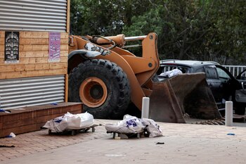 Los cadáveres de dos personas yacían en camillas en una zona residencial tras una infiltración masiva de hombres armados de Hamas desde la Franja de Gaza, en Sderot, sur de Israel, el 8 de octubre de 2023 (REUTERS/Ronen Zvulun)