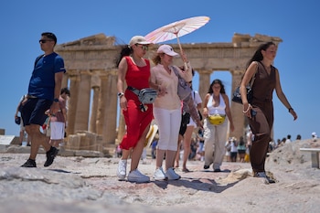 Tourists with an umbrella walk