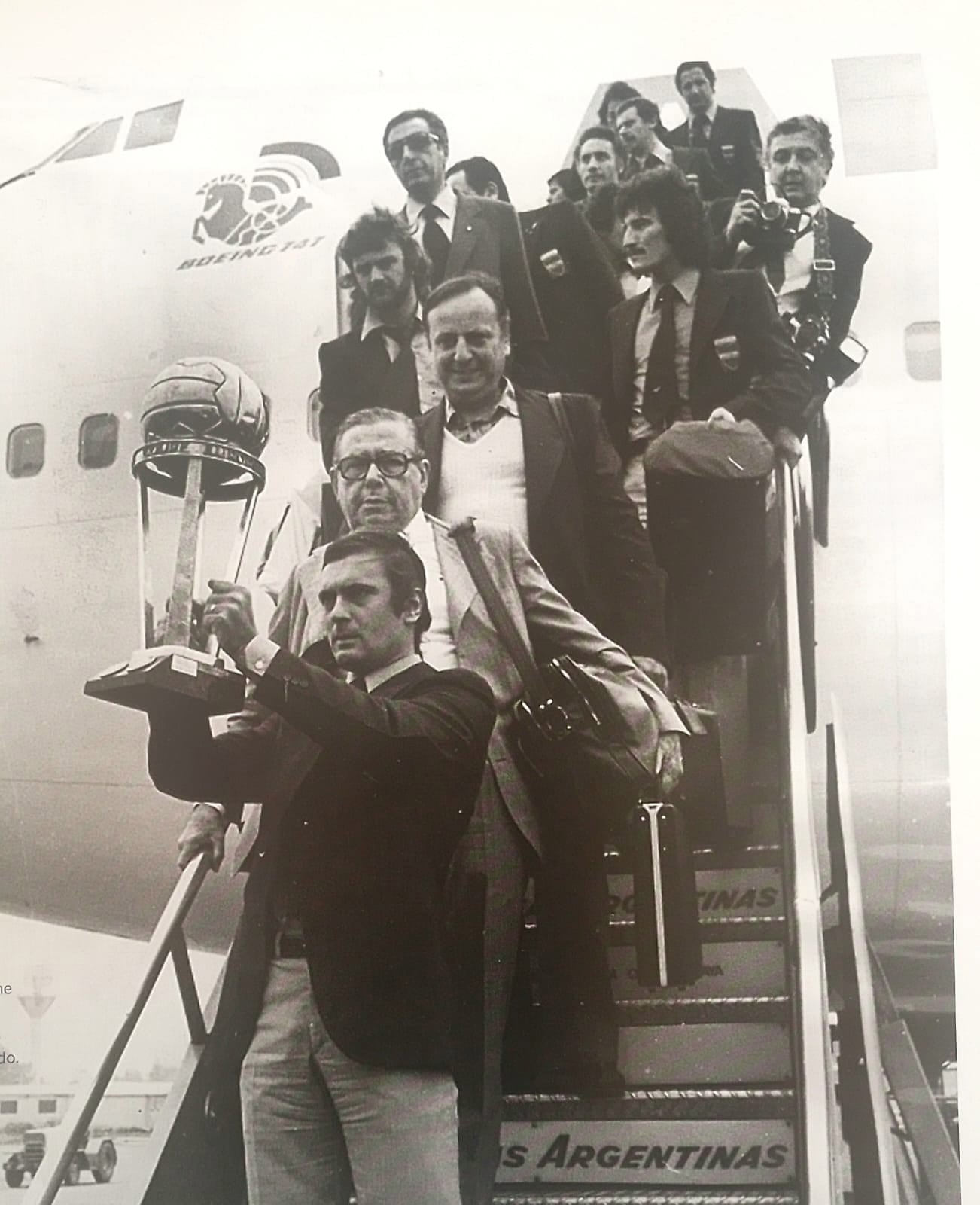 El capitán Rubén Suñé, muestra con orgullo la Copa Intercontinental, al llegar de Alemania en la escalerilla del avión, seguido del presidente Alberto J. Armando