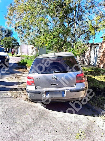 Parte trasera de un automóvil Volkswagen Golf gris detenido sobre el cordón de una calle residencial