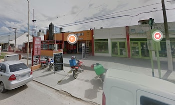 Frente de la rotisería Todo Casero con motocicletas en la vereda, carteles de precios y un automóvil gris estacionado