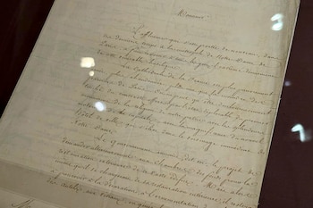 Una hoja de papel de color beige con texto manuscrito en tinta marrón, escrito en francés antiguo. El texto se extiende por toda la superficie visible