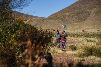 Indigenous men arrive dancing and