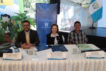 Tres personas sentadas tras una mesa con identificadores del Tribunal Supremo Electoral de Guatemala y una bandera