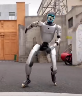 Un robot plateado y negro con una pantalla facial azul brillante está bailando en una calle urbana. Sus brazos están levantados y sus piernas flexionadas