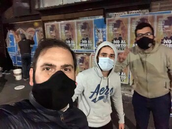 Militantes pegando los afiches en