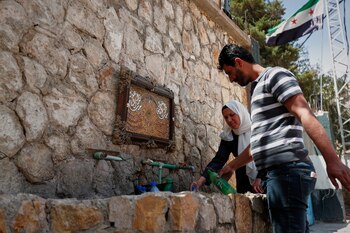 Visitantes llenan botellas con agua