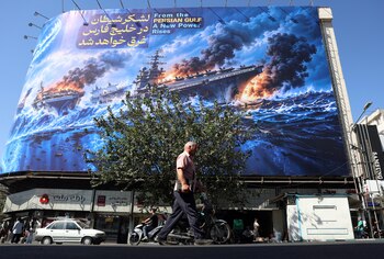 Iraníes caminan junto a una valla publicitaria antiamericana que muestra una frase en persa que dice: "El ejército del diablo se ahogará en el Golfo Pérsico", en la plaza Enghelab de Teherán, Irán, el 21 de septiembre de 2026 EFE/EPA/ABEDIN TAHERKENAREH