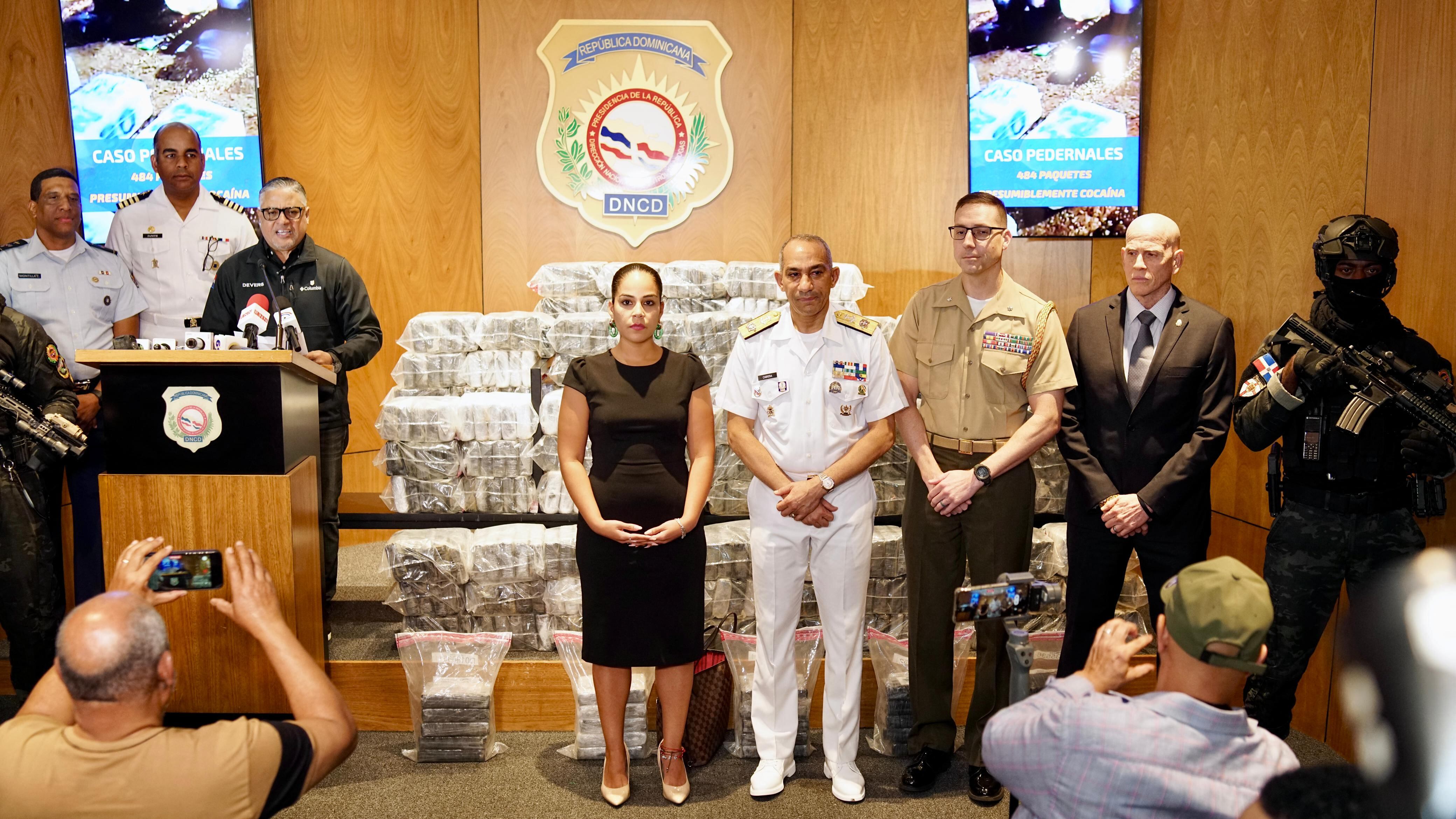 La representante de la embajada de Estados Unidos, Michelle Angulo, posó junto a las autoridades locales y los presuntos paquetes de cocaína en Santo Domingo el 15 de noviembre de 2025 (AFP)