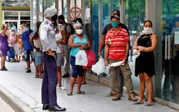 Personas con tapabocas hacen fila afuera de un centro comercial para comprar productos, en La Habana (Cuba), en una fotografía de archivo. EFE/Ernesto Mastrascusa