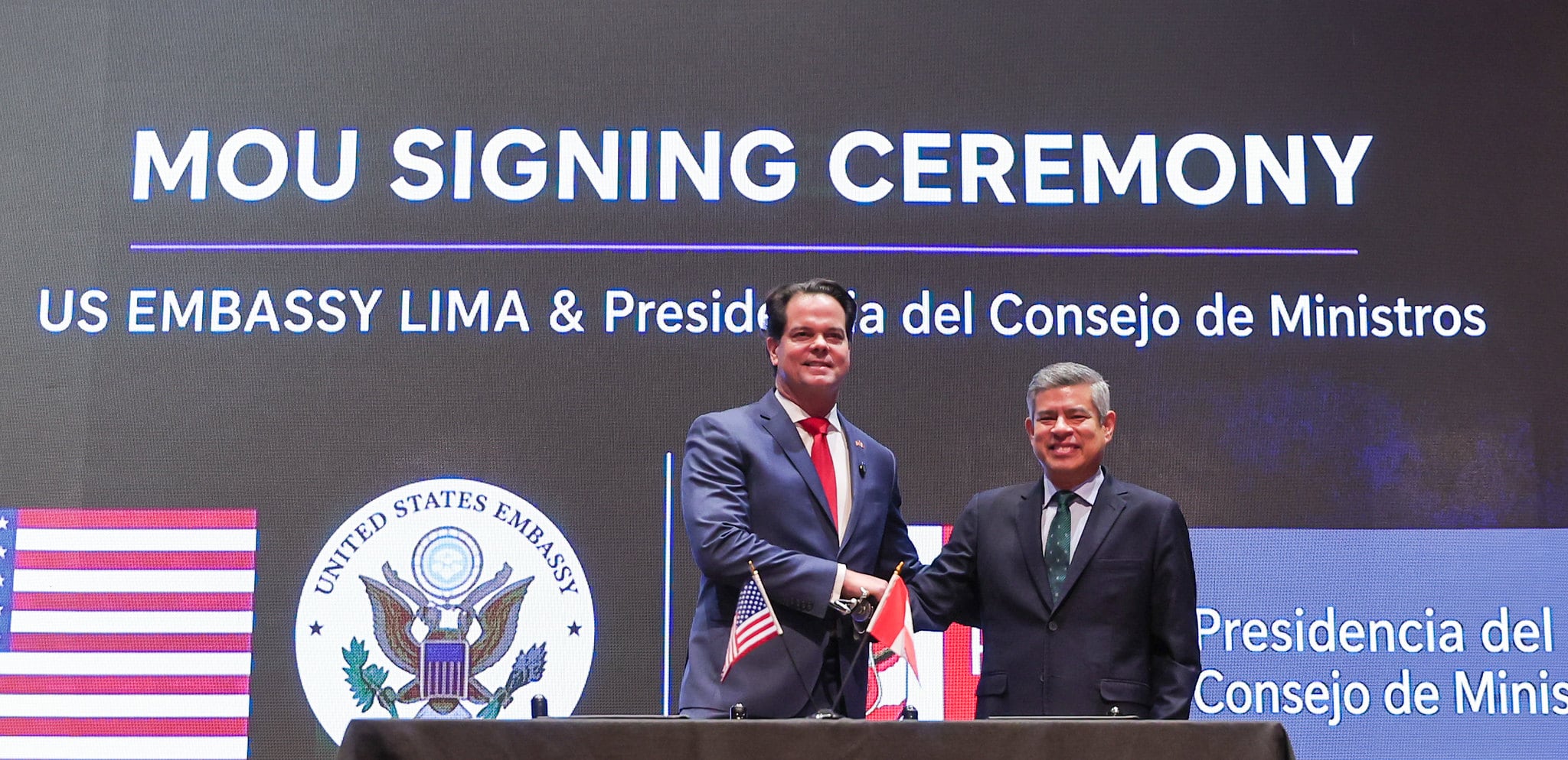 Luis Galarreta y el embajador Bernie Navarro estrechan la mano tras suscribir un acuerdo de cooperación sobre inteligencia artificial entre el Perú y Estados Unidos.