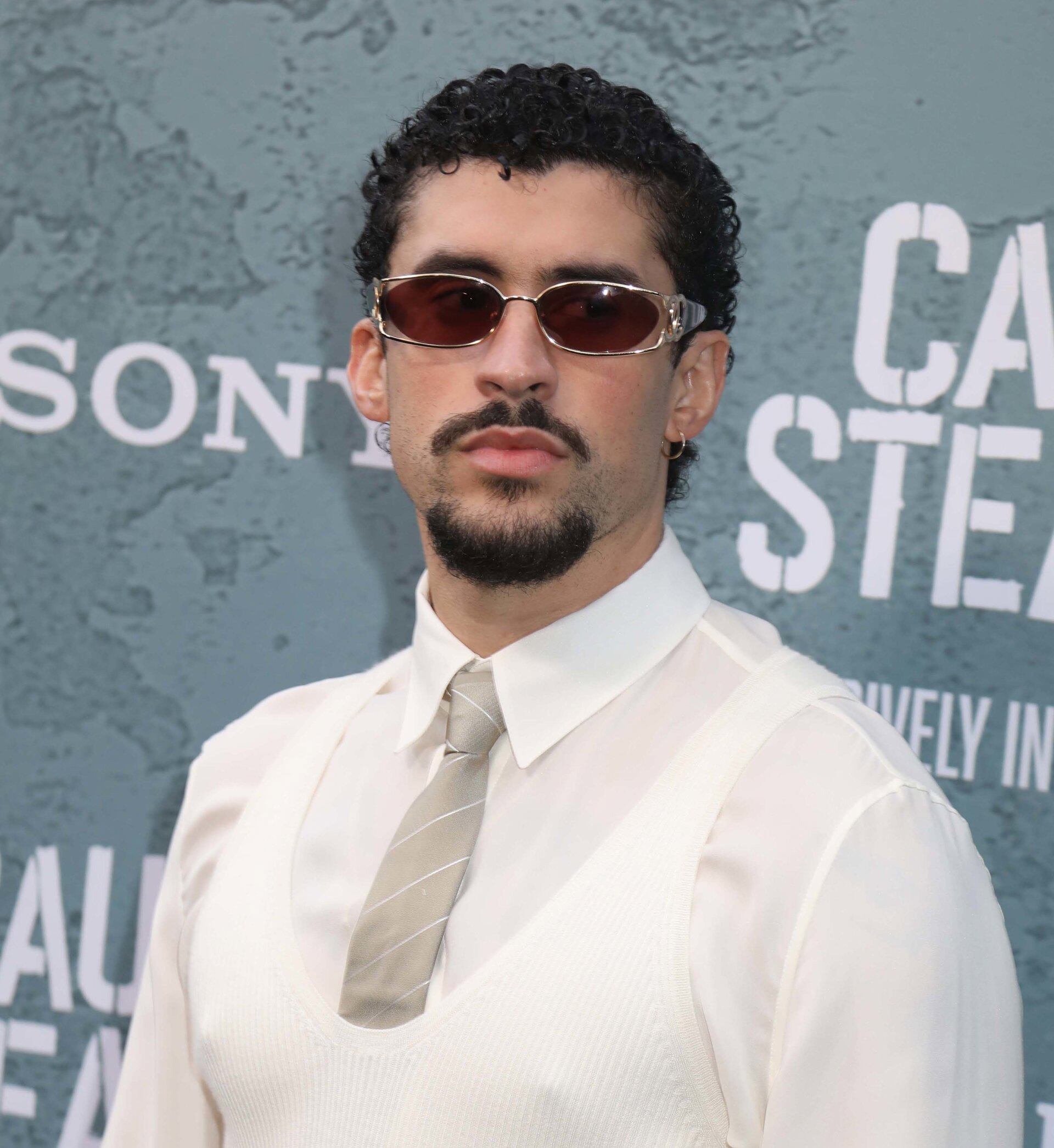 El chaleco de punto blanco y la corbata gris, acompañados de gafas rectangulares, consolidan una imagen casual y refinada (Europa Press)