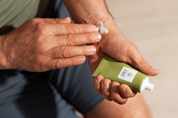 Un hombre se aplica crema solar (Magnific)
