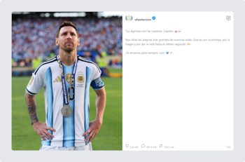 Lionel Messi con camiseta celeste y blanca de la Selección Argentina, luciendo una medalla plateada, en un campo de fútbol con público al fondo