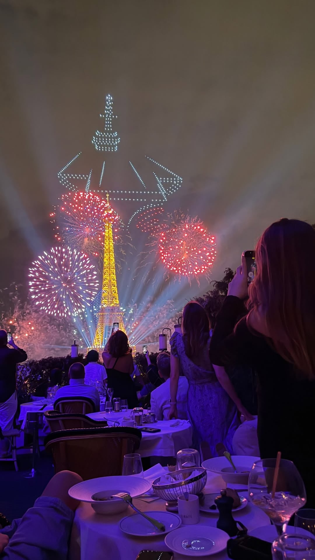 Cientos de drones formaron la silueta de la Torre Eiffel en el cielo de París durante el espectáculo nocturno que la familia presenció desde el restaurante Girafe